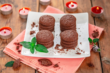 Homemade chocolate cookies in a white square porcelain dish and candles