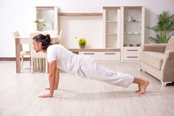 Young man doing physical exercises at home