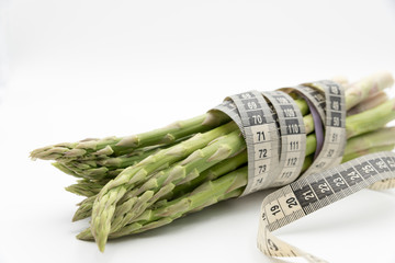 Asparagus surrounded by a medical tape on weighing scale for diets