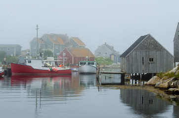 Fototapeta na wymiar Red and white boats in a foggy harbour