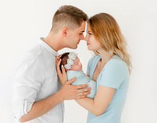 Obraz na płótnie Canvas young beautiful parents holding a newborn daughter