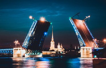 Fototapeta na wymiar A famous illuminated drawbridge in Saint Petersburg at night with lights reflected in water. Trinity or Troitskiy bridge. Travelling to Russia well-known sight. Beautiful night river view.
