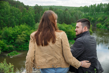 A man and a woman are resting on a hill of a mountain.