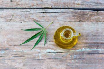 Cannabis oil in a bottle on a wooden background.