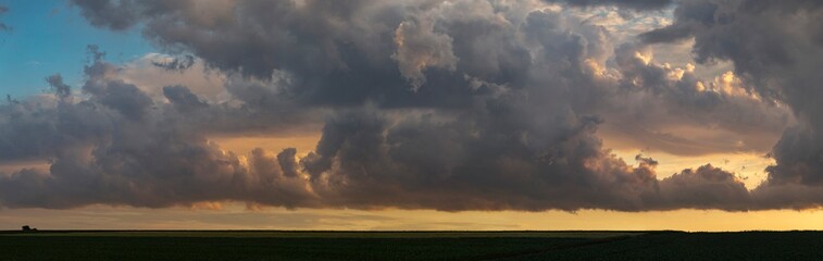 Leaden, storm clouds covered the sunset. Cumuliform cloudscape on blue sky. The terrain in southern Europe. Fantastic skies on the planet earth. Tragic gloomy sky.	