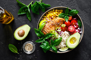 Grilled chicken breast lunch bowl with fresh tomato, avocado, corn, red onion, rice and basil