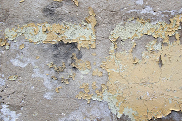 old cracked yellow green paint on the cement wall