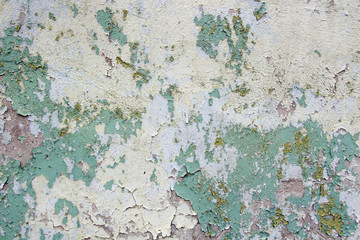 old cracked yellow green paint on the cement wall