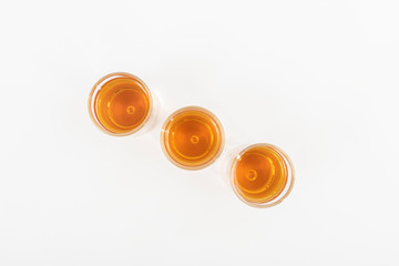 Top view of three shots of whiskey lined up and isolated on a white background