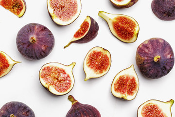 Whole and sliced ripe juicy figs on a white background. Top view.