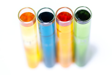 Test tubes filled with various water testing liquids on white background