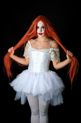Fototapeta premium girl with red hair in clown costume on black background
