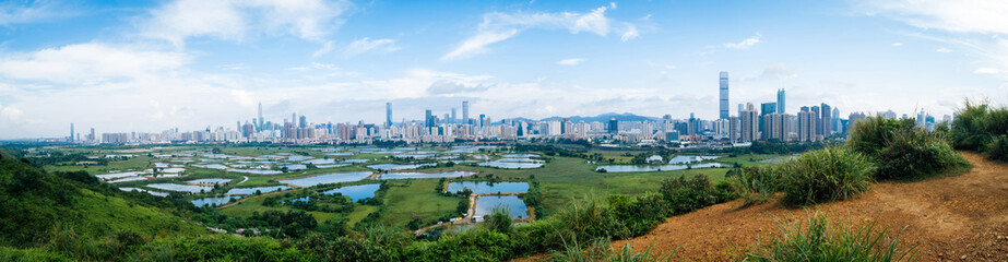 Panorama view of rural green fields with fish ponds between Hong Kong and skylines of Shenzhen,China