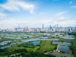 Fototapeta na wymiar Rural green fields with fish ponds between Hong Kong and skylines of Shenzhen,China