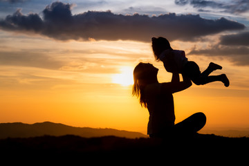 silhouette of woman on top of mountain with your daughter in sunset