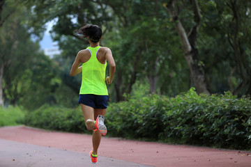 Fitness sporty woman jogger running at outdoors jogging track in park