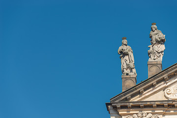Fototapeta na wymiar Decorative facade statues of priests and bishops at Saint Salvator church near Charles Bridge in Prague, Czech Republic, summer time, details