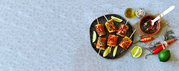 Pieces of corn on wooden sticks with spicy sauce and lime. Vegan food. Eco food.