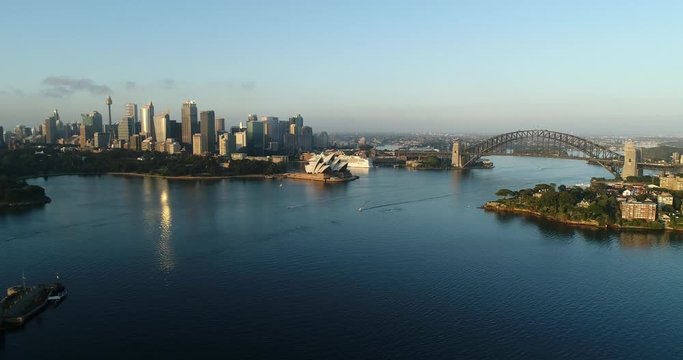 Blue waters of Sydney Harbour in view of major city CBD landmarks, Fort Denison and waterfronts of shores with residential buildings.