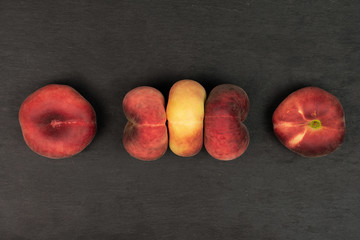 Group of five whole fresh red peach prunus persica platycarpa arranged symmetrically flatlay on...