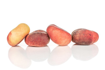 Group of four whole fresh red peach prunus persica platycarpa isolated on white background