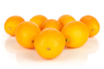 Lot of whole fresh orange kumquat arranged symmetrically isolated on white background