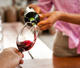 Hands pour wine in a glass