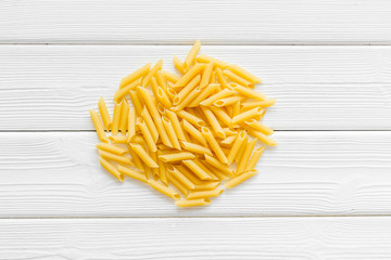 Uncooked pasta for italian food on white wooden table background top view