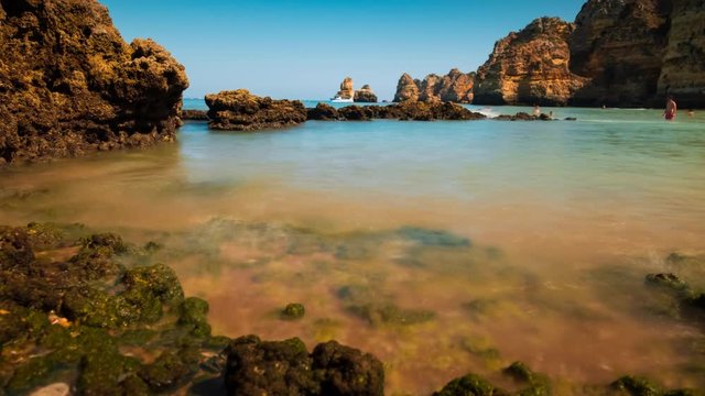 Stunning slow timelapse of Dona Ana beach in Lagos, The Algarve, Portugal featuring beautiful rock formations and pristine waters