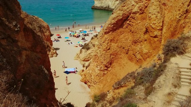 Establishing aerial wide view of pristine waters and beautiful rock formations in Tres Irmaos Beach in Alvor, The Algarve, Portugal