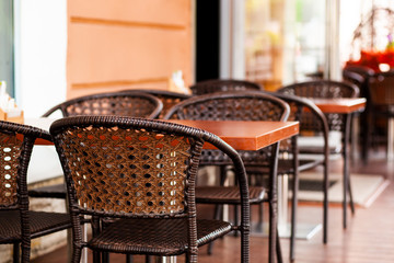 Cafe with wicker chairs and wooden tables on terrace
