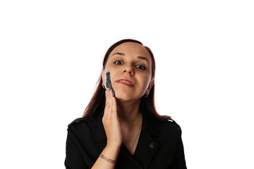 A young woman inflicts a black mask on the face isolated on white background.The concept of healthy lifestyle, beauty, body care.
