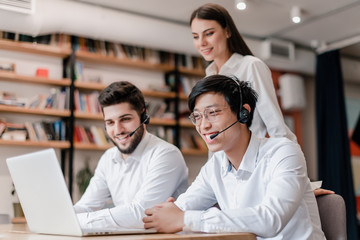 Fototapeta premium happy asian call center operator smiling with headset in the office