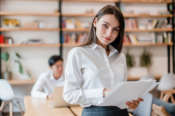 beautiful business woman in the modern company office with work papers