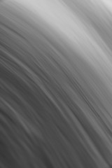 Abstract black and white photograph long exposure of water w/ blurred curved streaks or ripples texture making a great creative background gradient or backdrop wallpaper image.