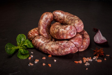 closeup homemade raw sausages with onion and basil