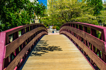 Wooden Walking Over River Leading To Downtown Area