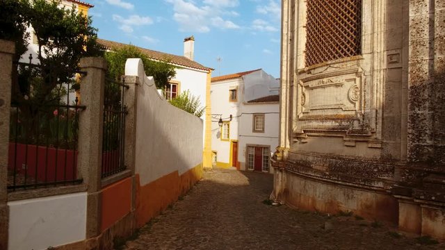 Discovering the narrow and picturesque streets of Evora, Portugal, featuring the famous whitewashed houses with yellow accents. Enclosed by medieval walls, Evora is a UNESCO World Heritage Site
