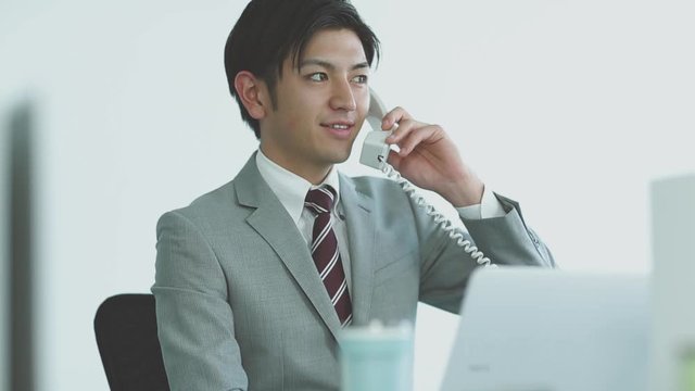 Businessman talking on phone at desk in office