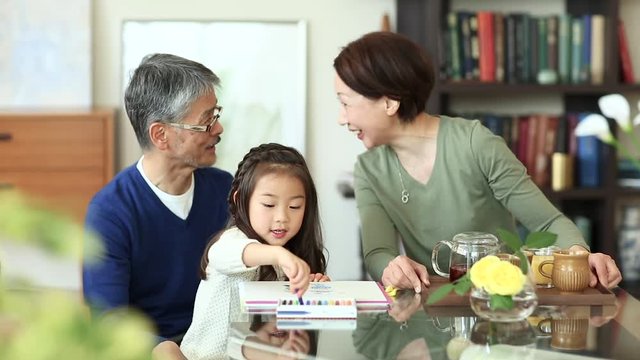 Grandparents with granddaughter drawing and talking