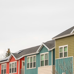 Square frame Exterior view of homes with small balconies and multi color sidings on the wall
