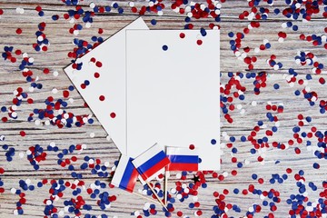 the independence day of Russia. June 12 . the concept of patriotism, freedom and independence. mini flags with red white blue and confetti white card on wooden background