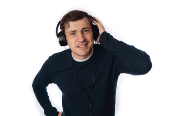 beautiful young man in headphones is dancing isolated on white background. The concept of International Music Day.