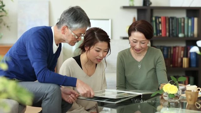 Family in salon looking at photo album, Osaka, Japan