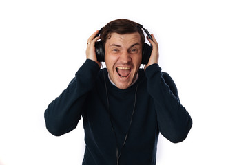 beautiful young man in headphones is dancing isolated on white background. The concept of International Music Day.