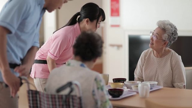 Caregivers talking to patients in nursing home canteen