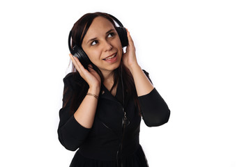 Fototapeta premium A beautiful young woman in headphones is dancing isolated on white background. The concept of International Music Day.