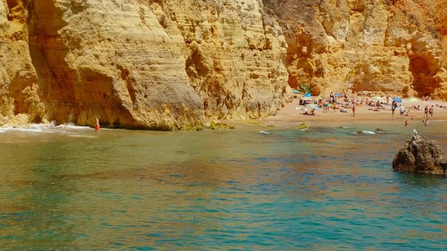 Close-up shot of Pinhao Beach, Lagos, The Algarve, Portugal, a secluded cove with clear water and towering orange cliffs