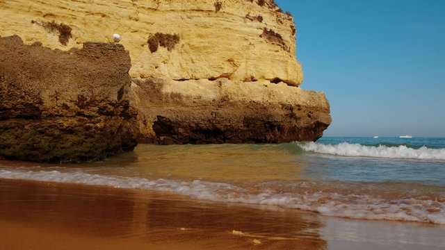 Beautiful sunset slow motion of pristine waters and beautiful rock formations in Dona Ana beach, Lagos, The Algarve, Portugal