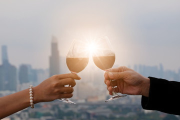 Duration couple romantic dinner time on the terrace at the restaurant, Hand holding red wine and bokeh light , Night city background. Valentine's concept , Dinner Concept.